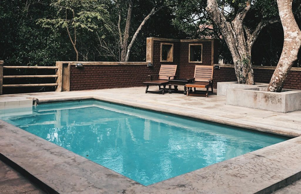 two lounge chairs near swimming pool